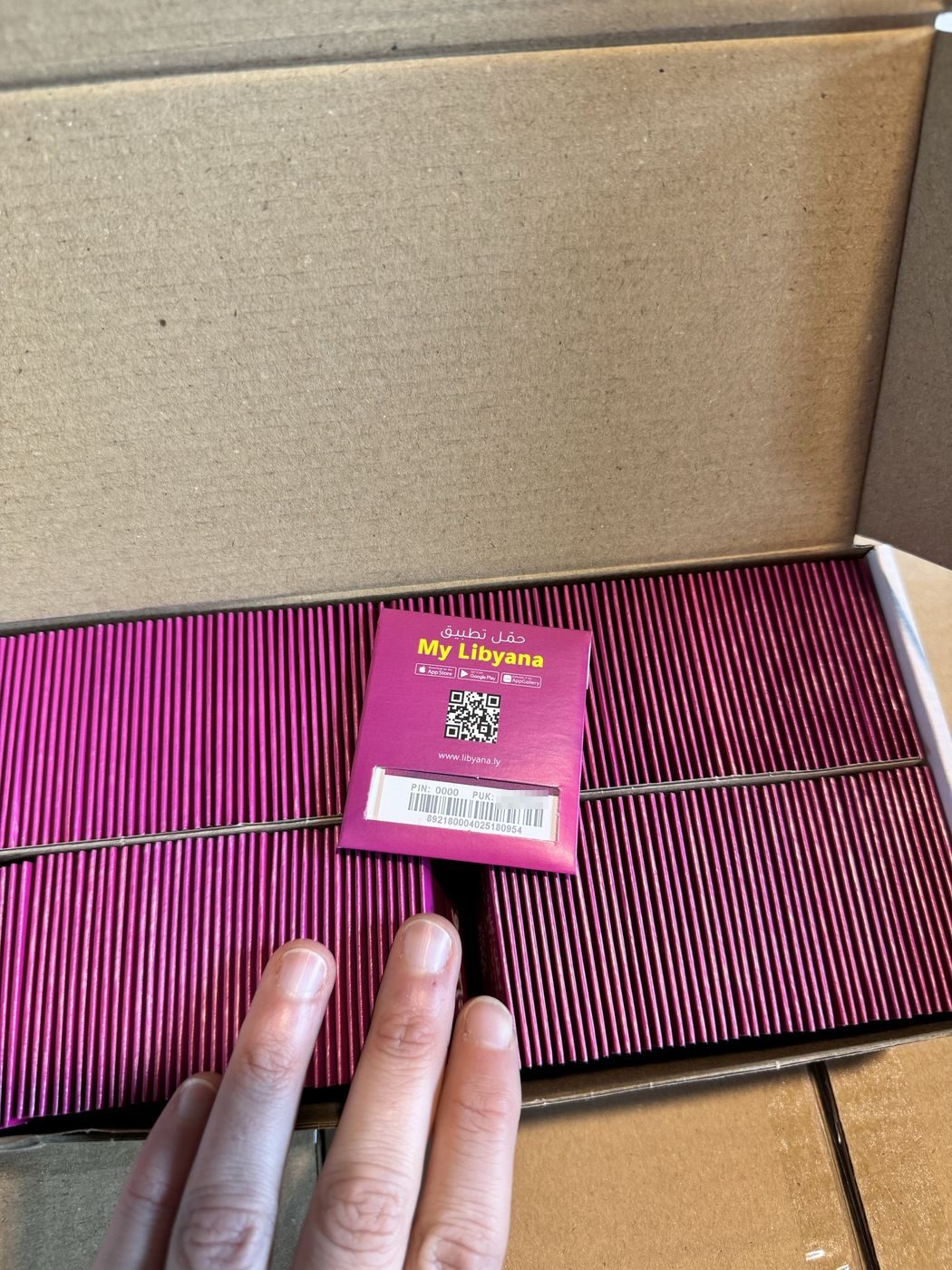 Box filled with hundreds of purple half-card SIM packs