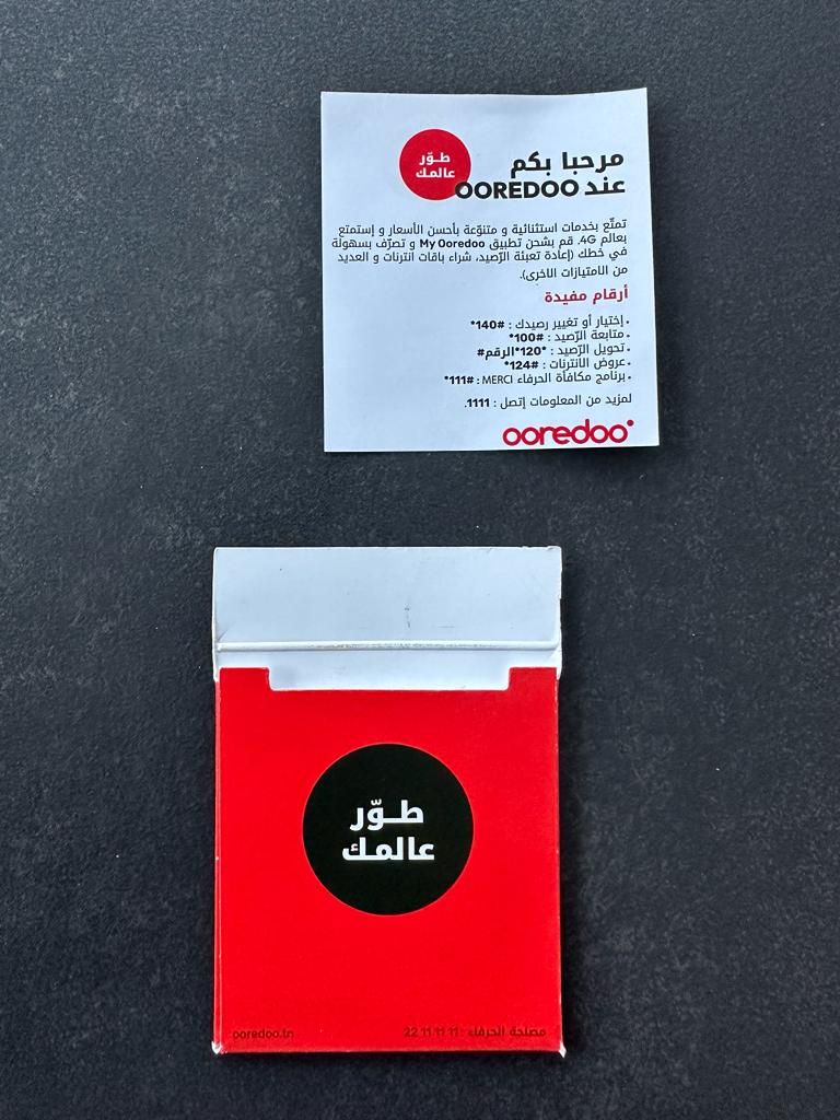 Welcome leaflet and red pack on a dark surface